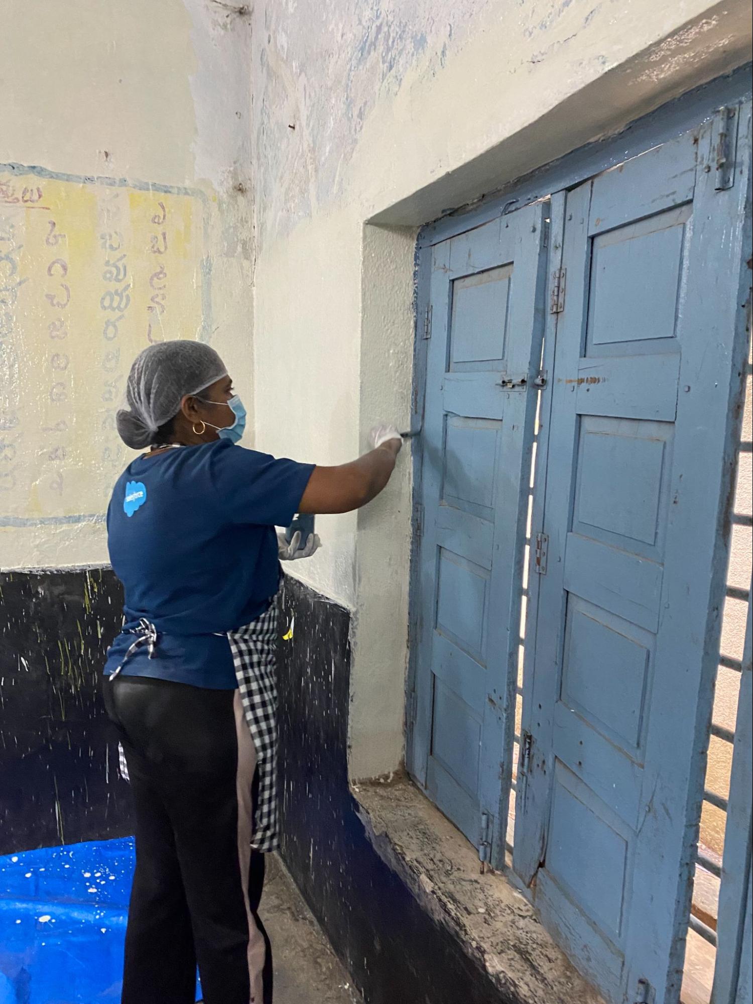 Suma Sushilendra painting a door